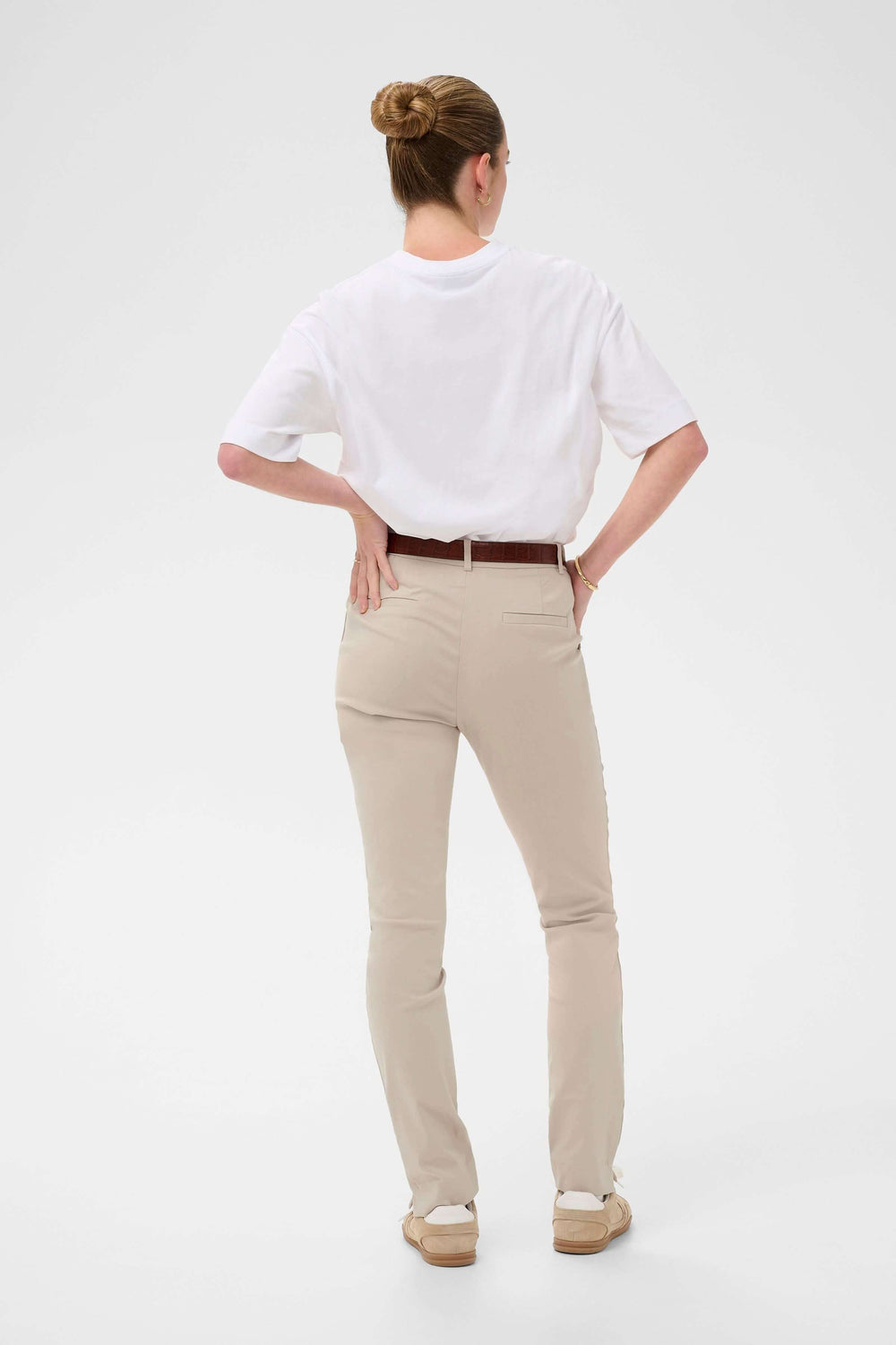 Dos d'une femme en pantalon habillé Hazel coupé ajusté, porté avec une chemise blanche, mettant en valeur l'élégance et le confort.