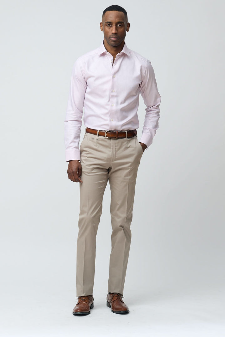 Homme portant un pantalon habillé coupe ajustée, chemise rose et chaussures marron, offrant un look élégant et polyvalent.