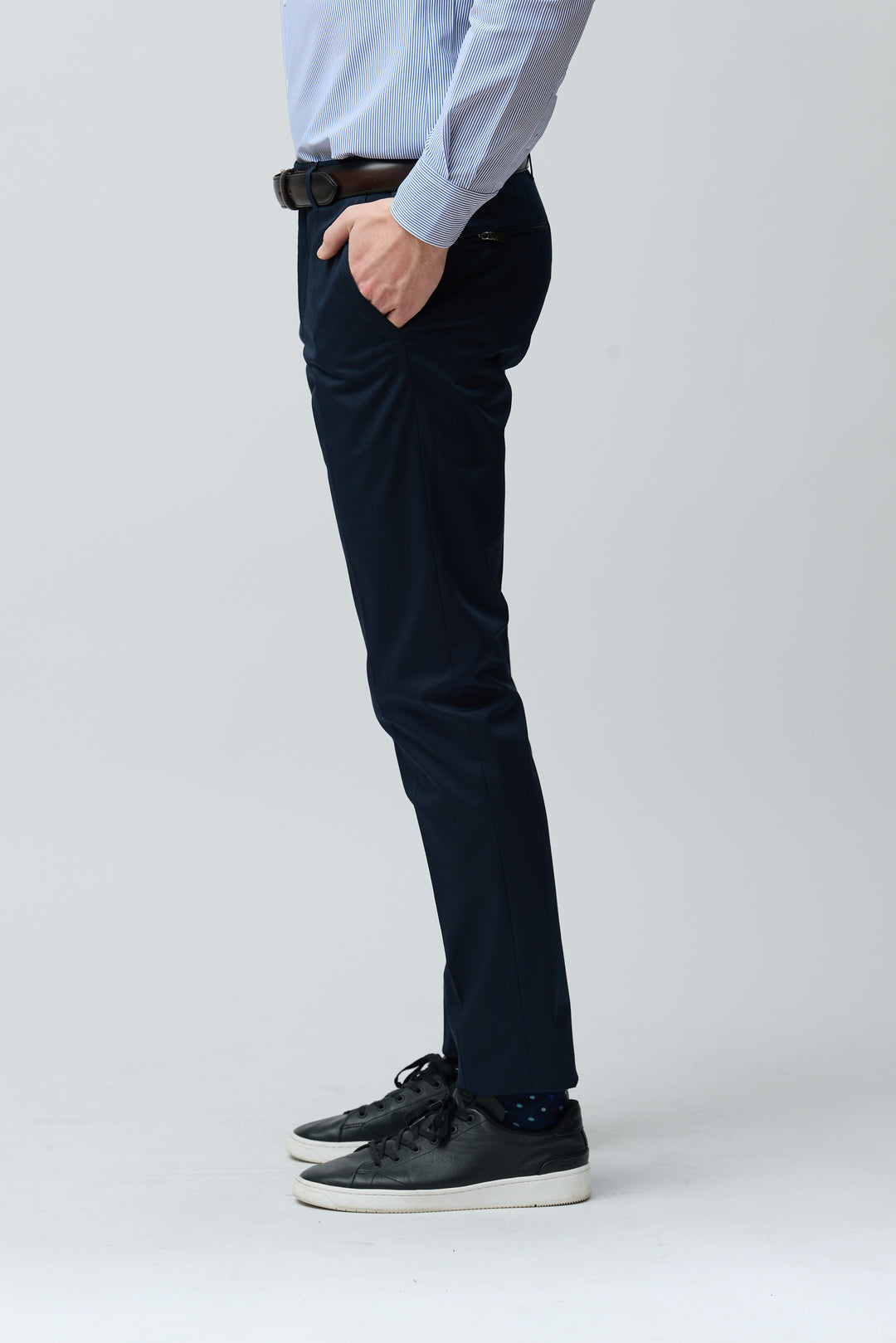 Homme portant un pantalon habillé coupe ajustée avec chemise et ceinture, idéal pour un look professionnel ou décontracté.