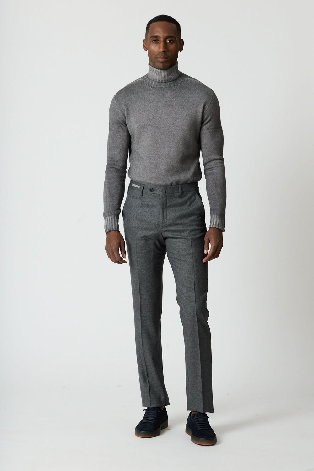 Pantalon habillé en laine à petits carreaux porté par un homme, coupe ajustée et élégante pour un style chic et sophistiqué.