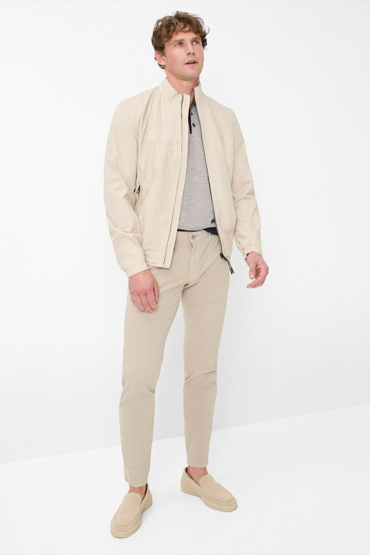 Homme portant un pantalon jambe droite Silvio avec un blouson beige et des chaussures décontractées.