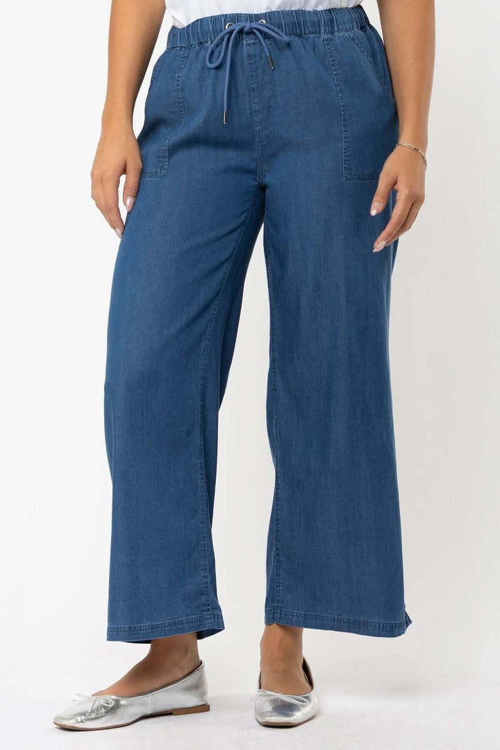 Pantalon à jambe large en denim bleu avec taille élastique et cordon ajustable, parfait pour un look décontracté.