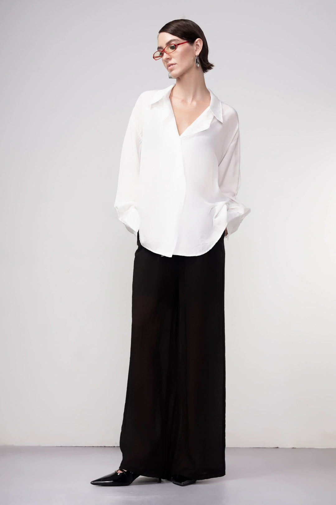 Pantalon jambe large noir avec taille élastique, coupe fluide. Parfait pour une tenue décontractée ou élégante. Mode moderne femme.