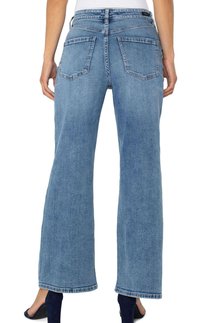 Jean à coupe large taille haute, denim délavé, vue arrière, style moderne et décontracté.