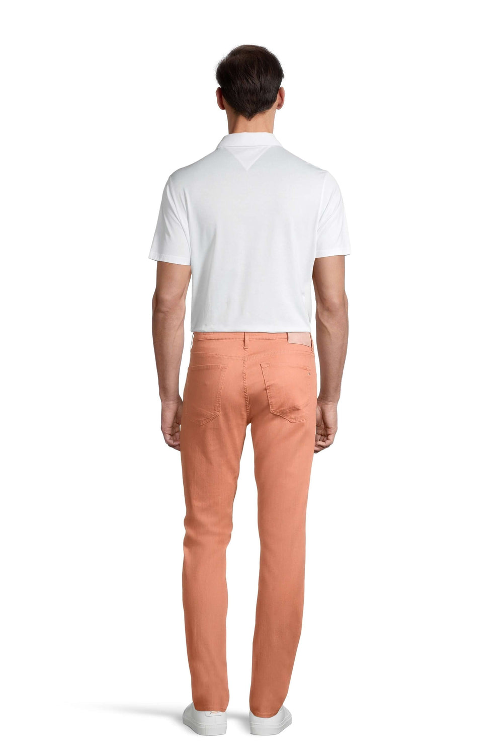 Homme de dos portant un pantalon à taille élastique orange et un polo blanc.