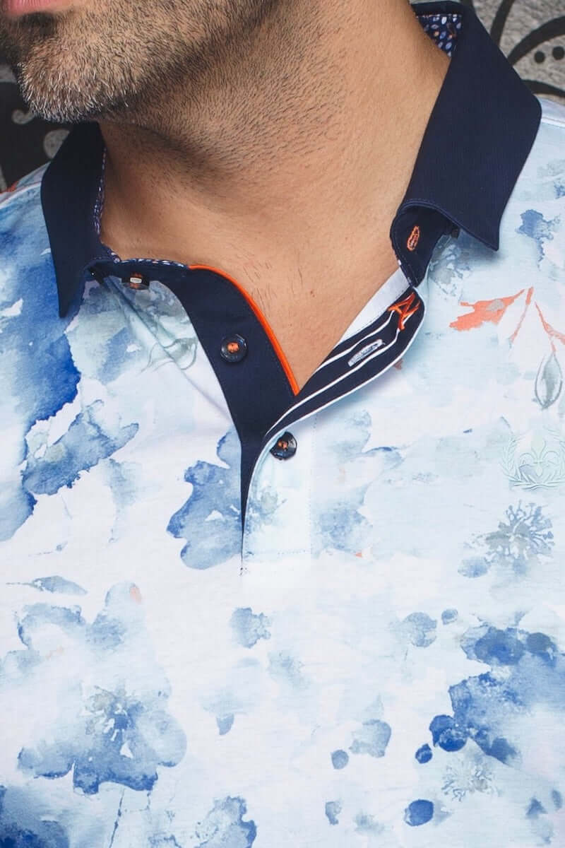 Polo Anzio avec motifs floraux bleus et col contrastant, conçu en coton mercerisé haut de gamme.