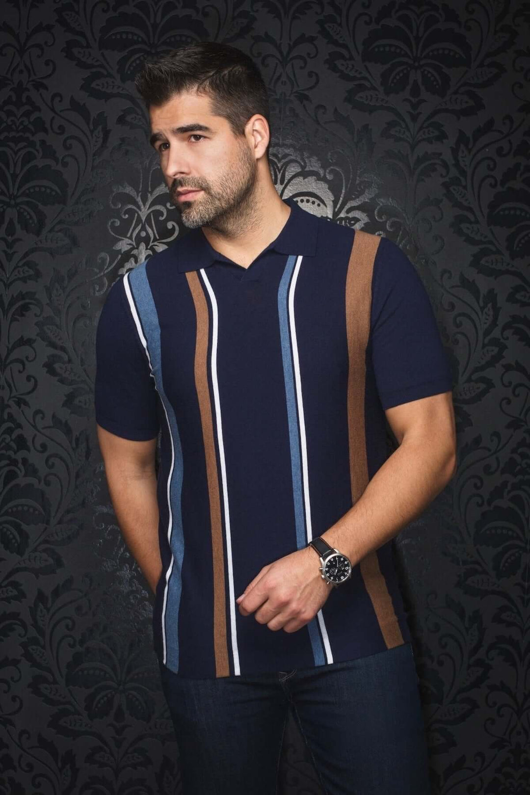 Homme portant un polo à rayures verticales bleues et brunes, style rétro, sur fond noir élégant.