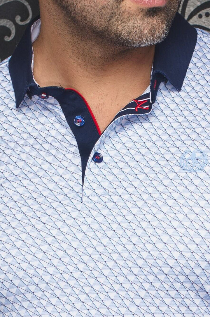 Polo élégant à motif géométrique en bleu et rouge, col navy avec détails contrastants pour un look estival.