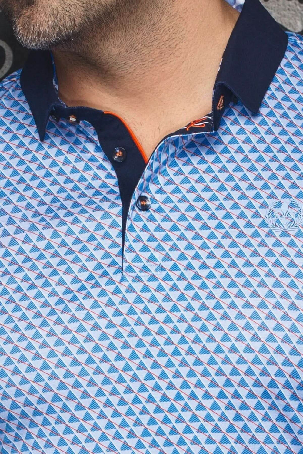 Polo à motif géométrique avec col marine et intérieur orange, élégant et décontracté.