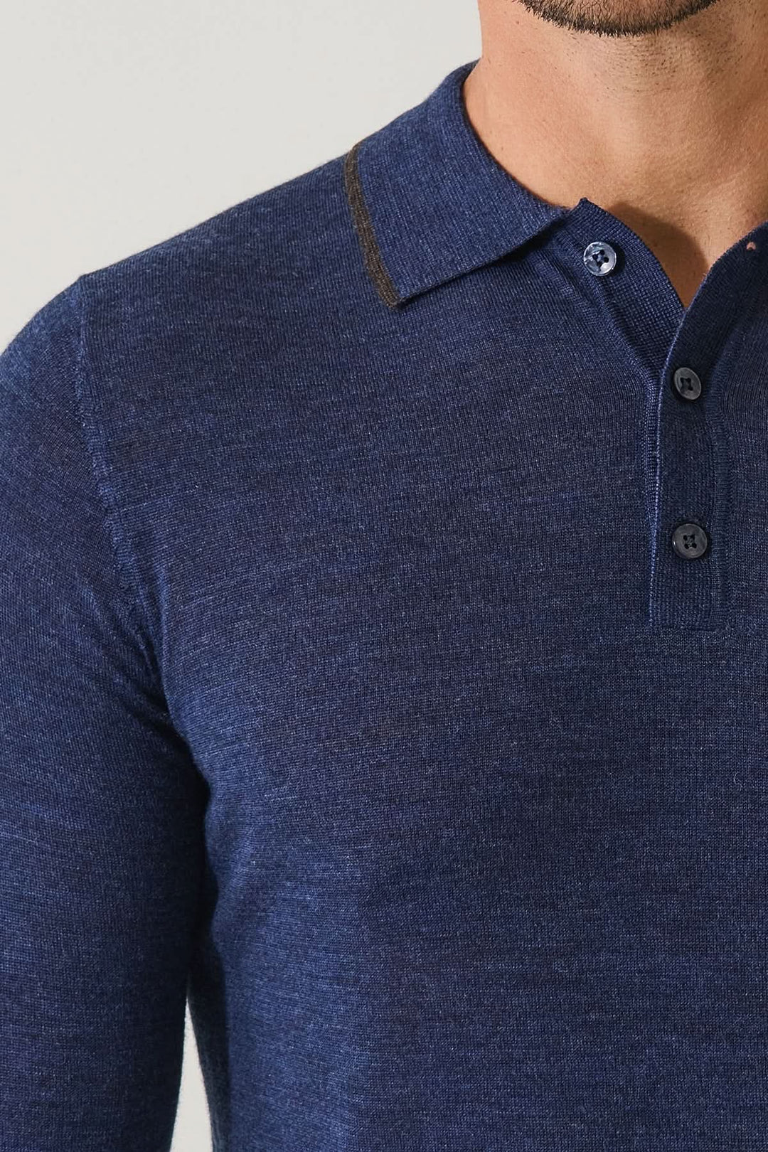 Polo boutonné en laine mérinos extra-fine, bleu marine, détail des boutons et texture fine pour élégance quotidienne.