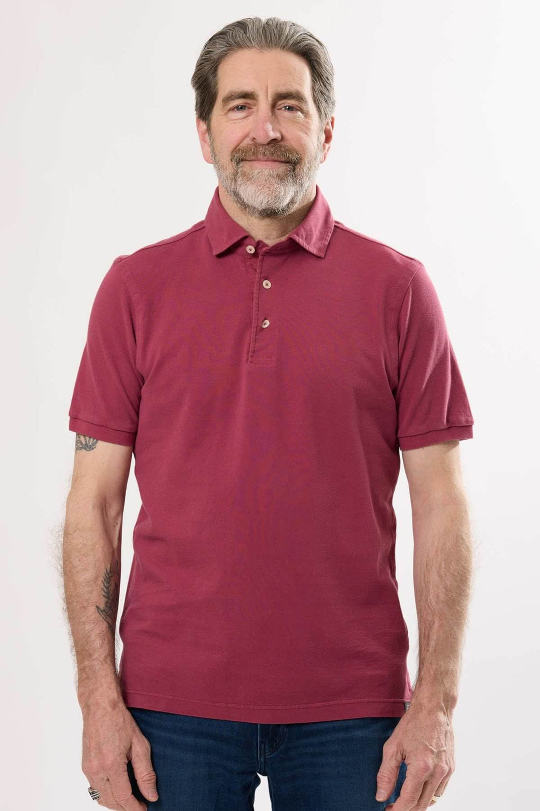 Homme portant un polo classique en coton doux, col en maille piquée, teinte unie et manches courtes.