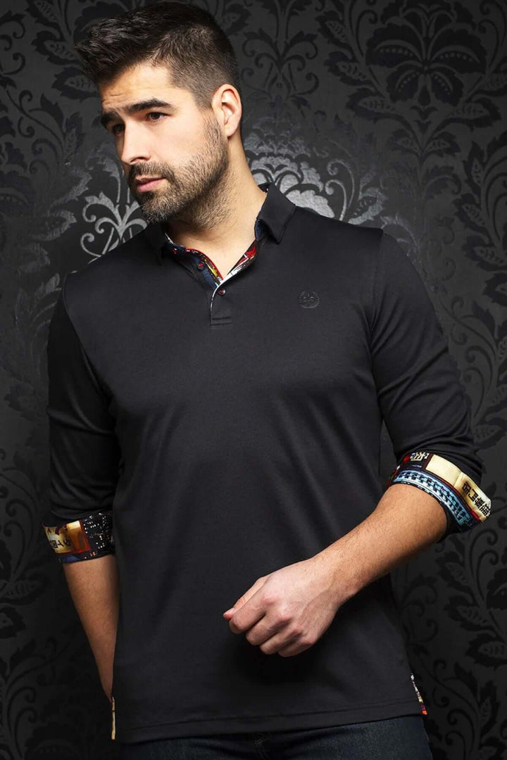 Homme portant un polo long noir avec col structuré et manches contrastées, élégant et décontracté.