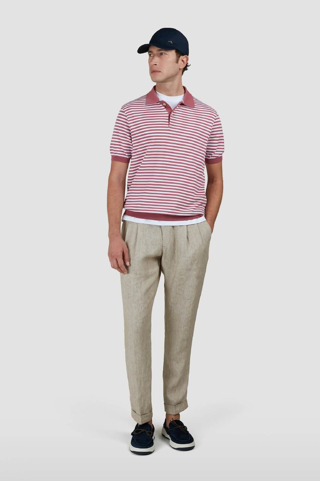 Homme portant un polo en coton à rayures bicolores avec un col contrasté et un pantalon beige.