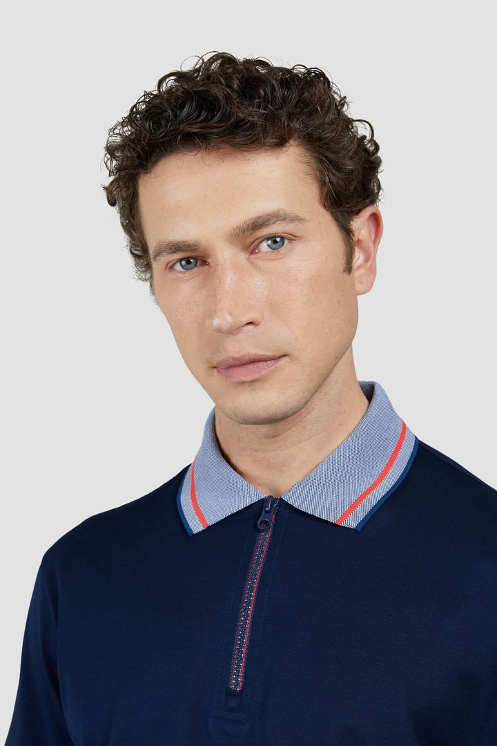 Homme portant un polo en coton avec col contrastant et fermeture éclair, style décontracté et moderne.