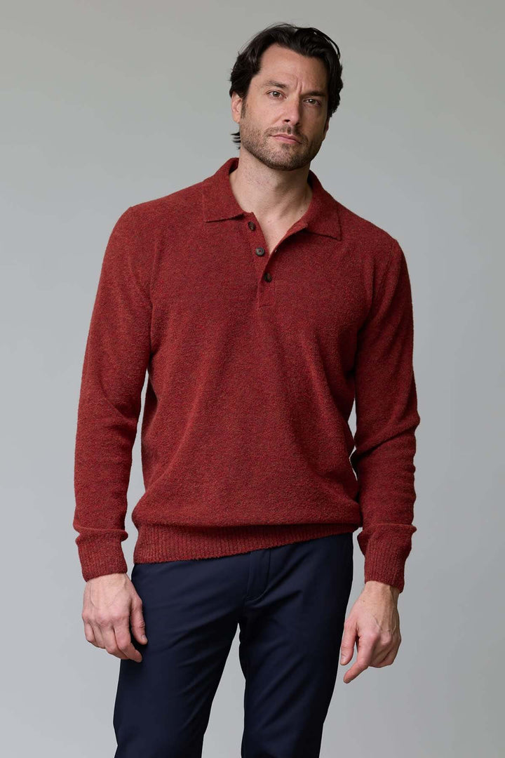 Homme portant un polo en laine mérinos rouge avec col classique à trois boutons, coupe ajustée et élégante. Parfait pour un look décontracté.