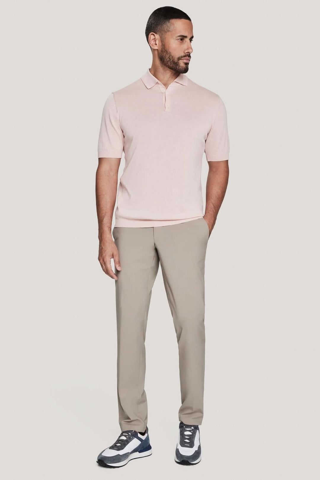 Homme portant un polo en tricot de coton et soie, avec un look élégant et décontracté, associé à un pantalon clair.