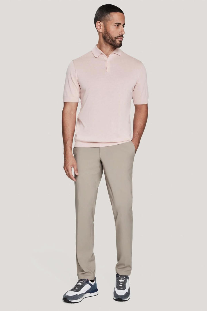 Homme portant un polo en tricot de coton et soie, avec un look élégant et décontracté, associé à un pantalon clair.