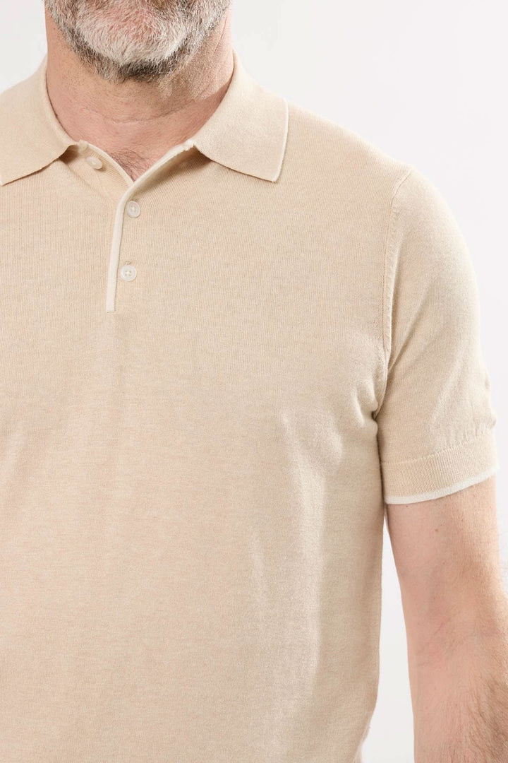 Polo en tricot fin beige pour homme, style sobre et raffiné avec col classique et manches courtes.