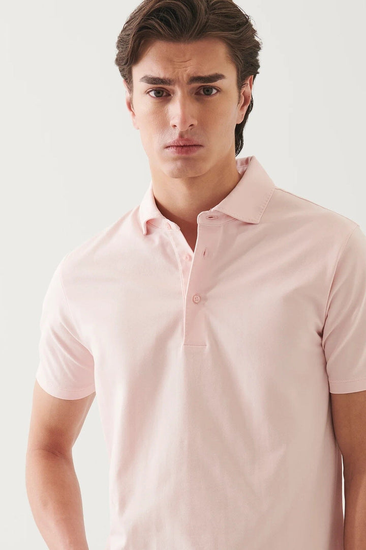 Homme en polo manches courtes rose, au design minimaliste et confort doux, parfait pour l&
