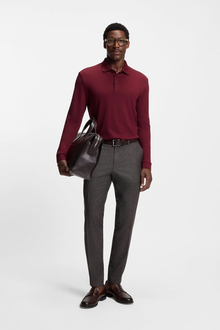 Homme portant un Polo manches longues Pado bordeaux avec un pantalon gris et un sac en cuir, représentant l&
