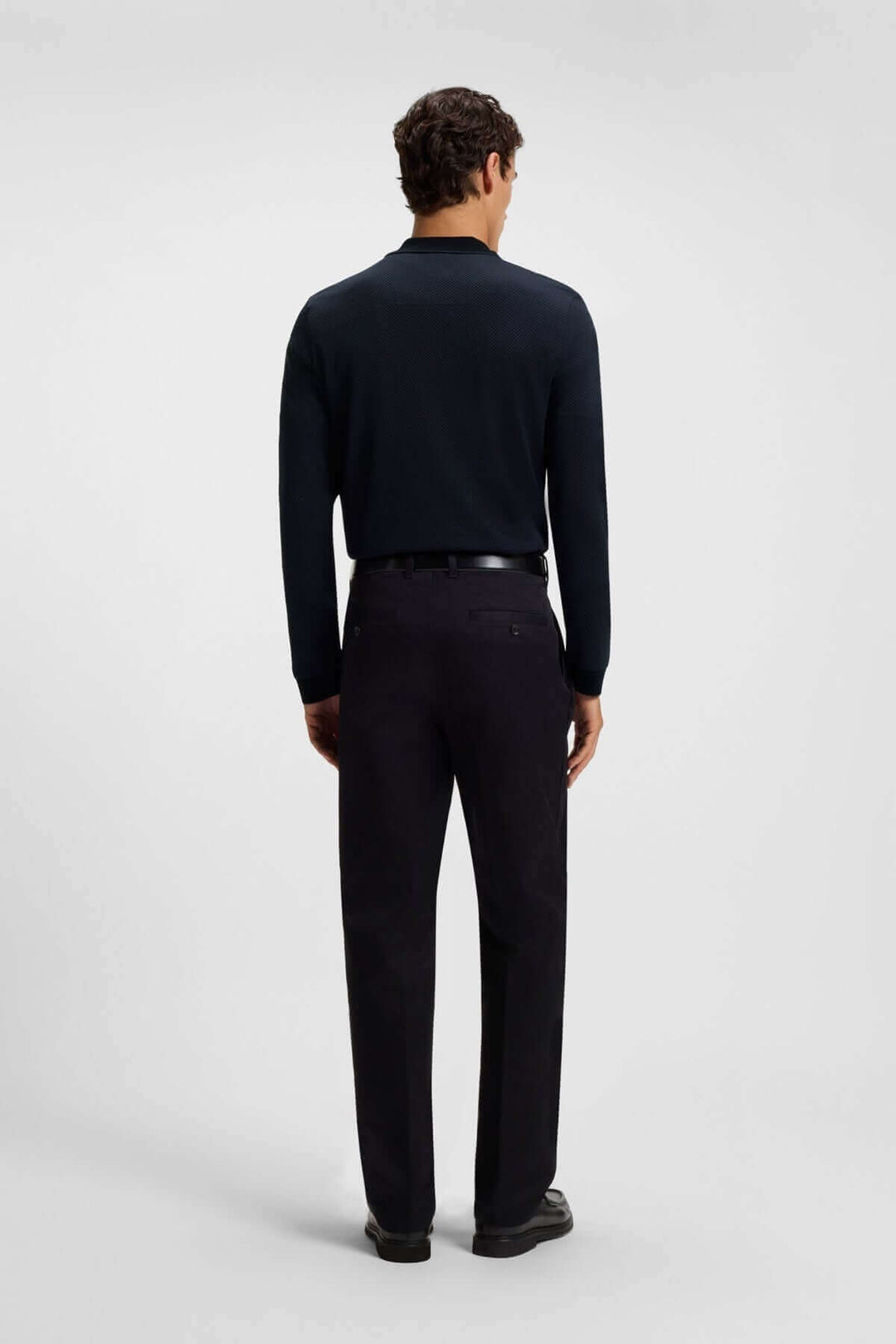 Homme en polo à manches longues avec fermeture éclair, vue de dos, style contemporain, col contrastant, pour un look élégant et décontracté.