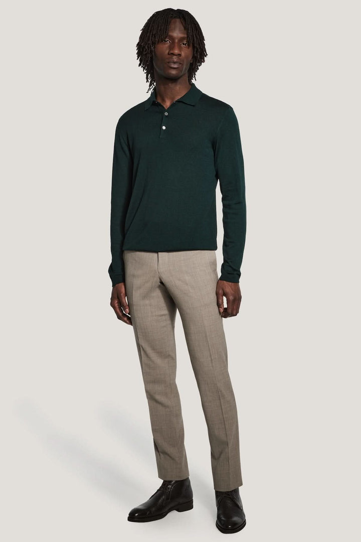 Polo manches longues en laine mérinos et soie, homme portant polo vert foncé et pantalon beige. Modes élégante et moderne.