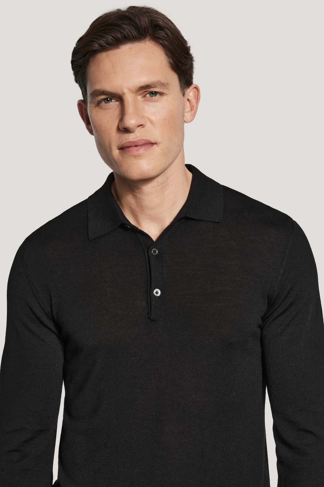 Polo manches longues en laine mérinos et soie tricoté en maille fine calibre 14, élégant et moderne, porté par un modèle homme.