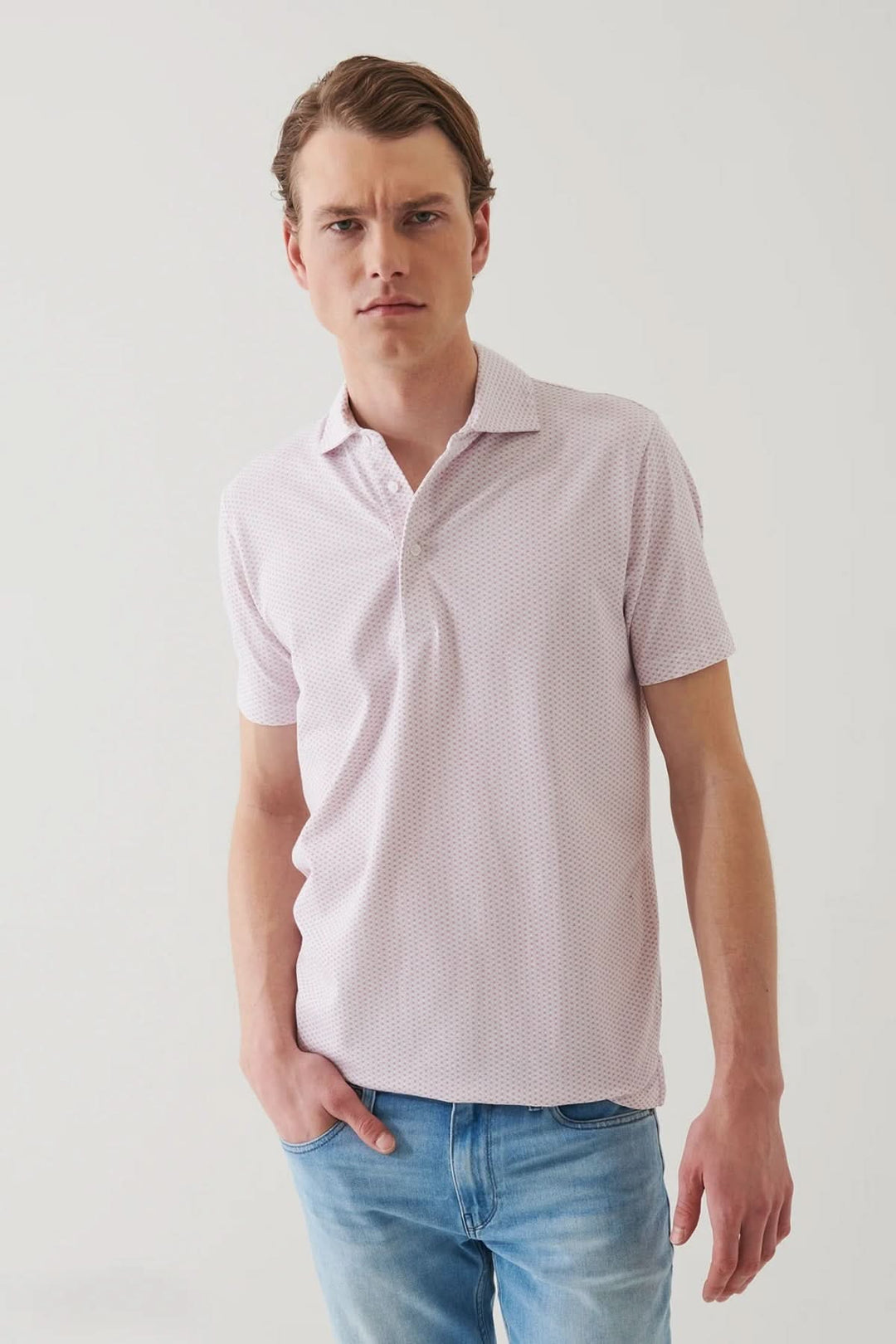 Polo à motif géométrique léger et élégant, coupe décontractée, porté avec un jean, look estival raffiné.