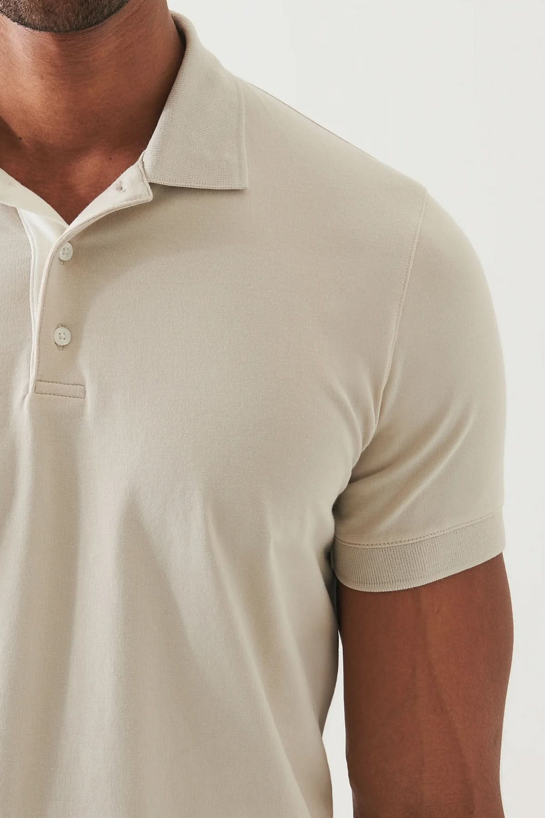 Polo épuré à manches courtes, coupe ajustée, tissu doux et léger, couleur neutre pour un style élégant et décontracté.