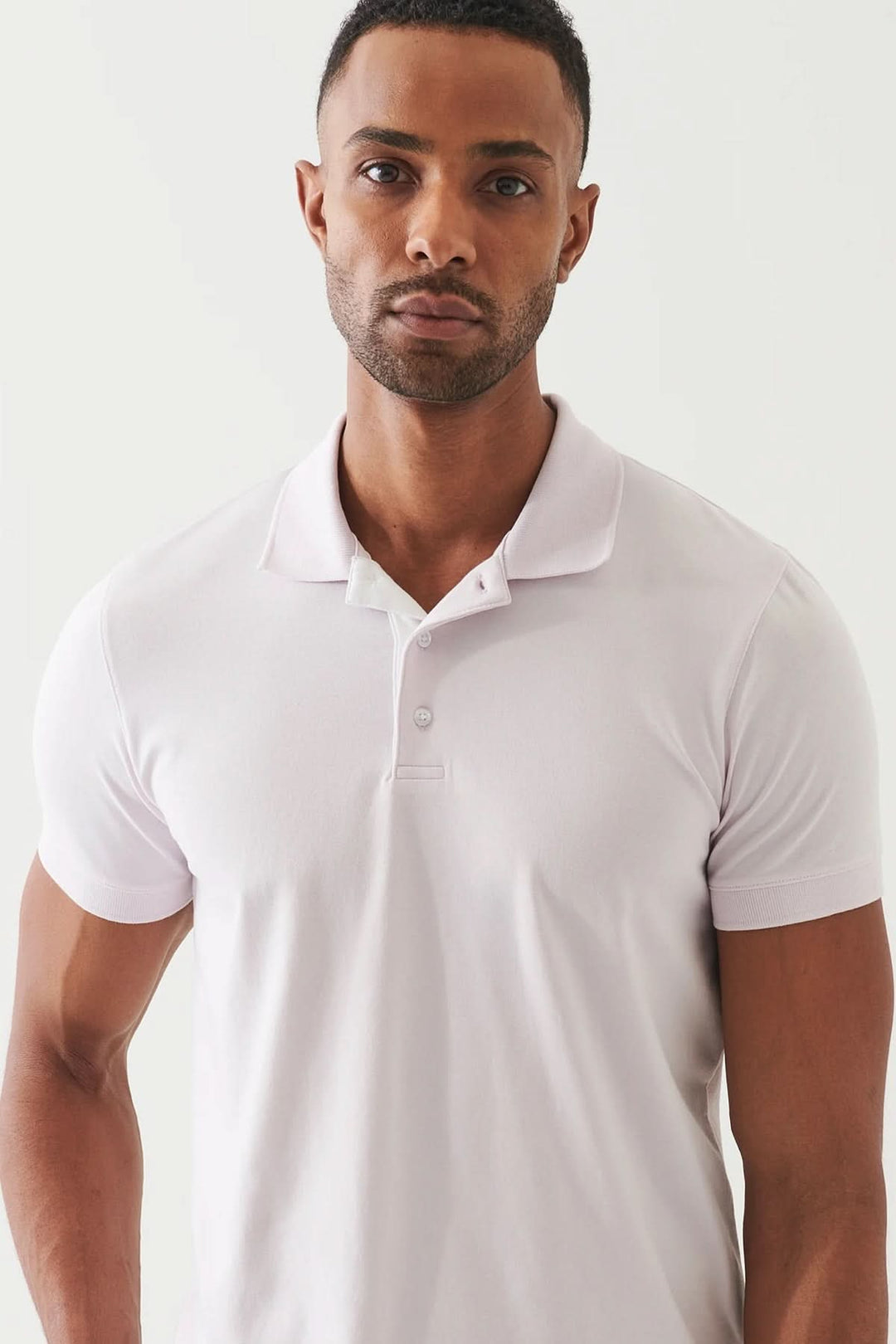 Polo épuré à manches courtes, coupe ajustée et tissu doux, parfait pour un style décontracté soigné.