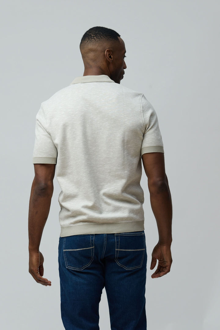 Homme portant un Polo texturé à fermeture zippée en coton peigné et flammé avec un look décontracté, vue de dos.