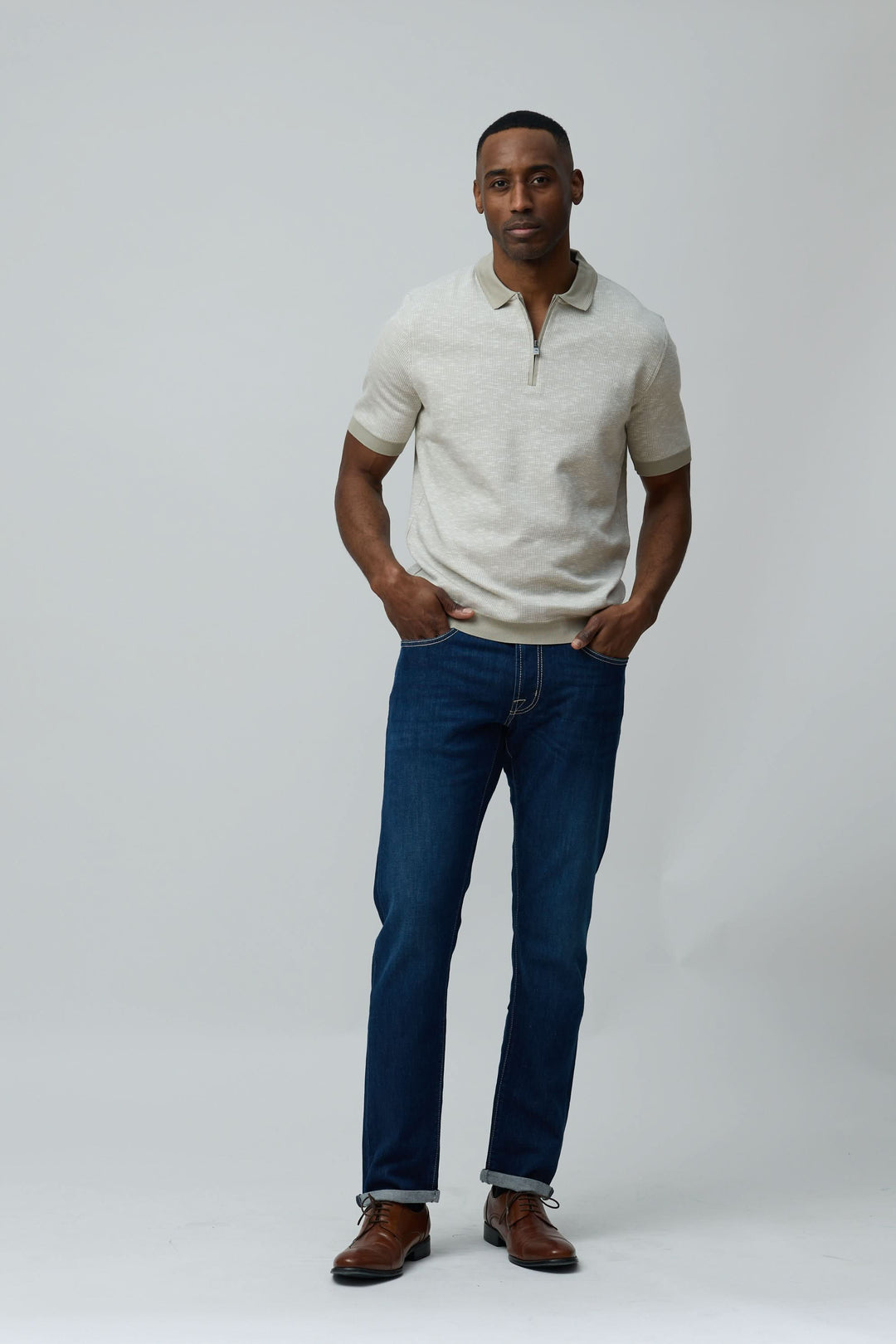 Homme portant un polo texturé à fermeture zippée en coton, idéal pour des looks décontractés ou soignés, offrant confort et respirabilité.