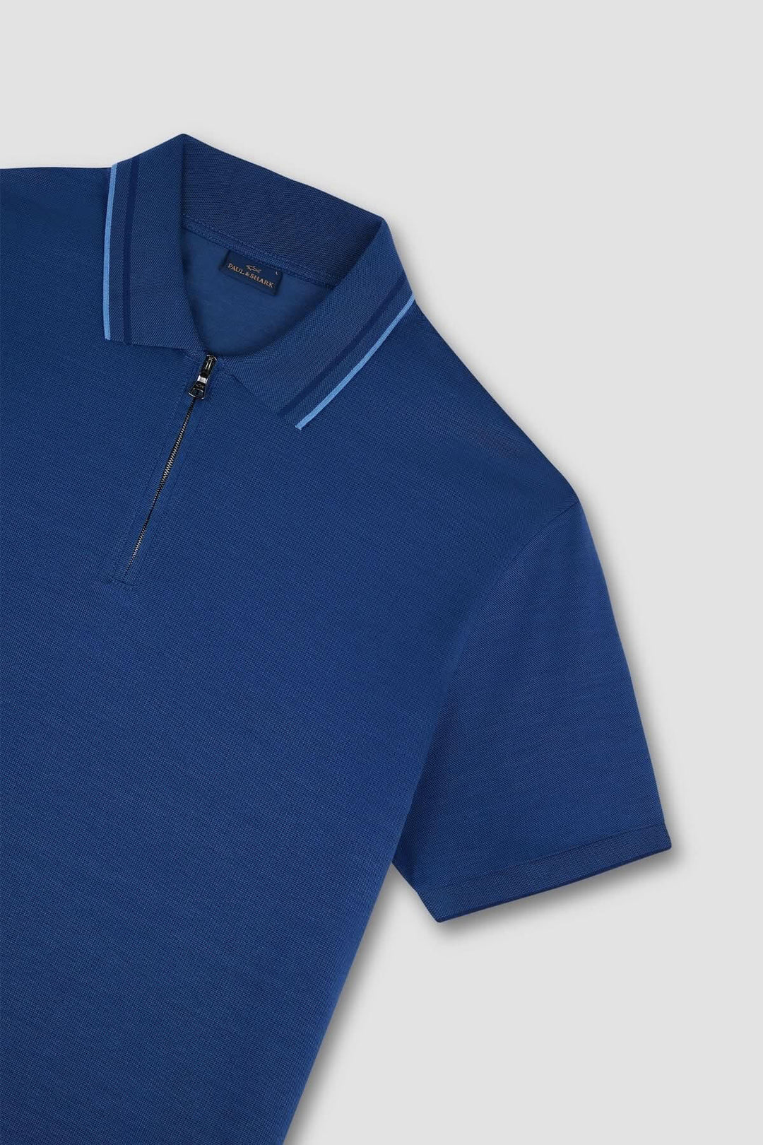 Polo zippé en coton bleu avec col contrasté, élégant et moderne pour un look sophistiqué.