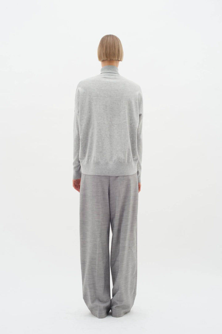 Pull à col roulé Kellsie en maille douce, porté avec un pantalon ample, vue de derrière.