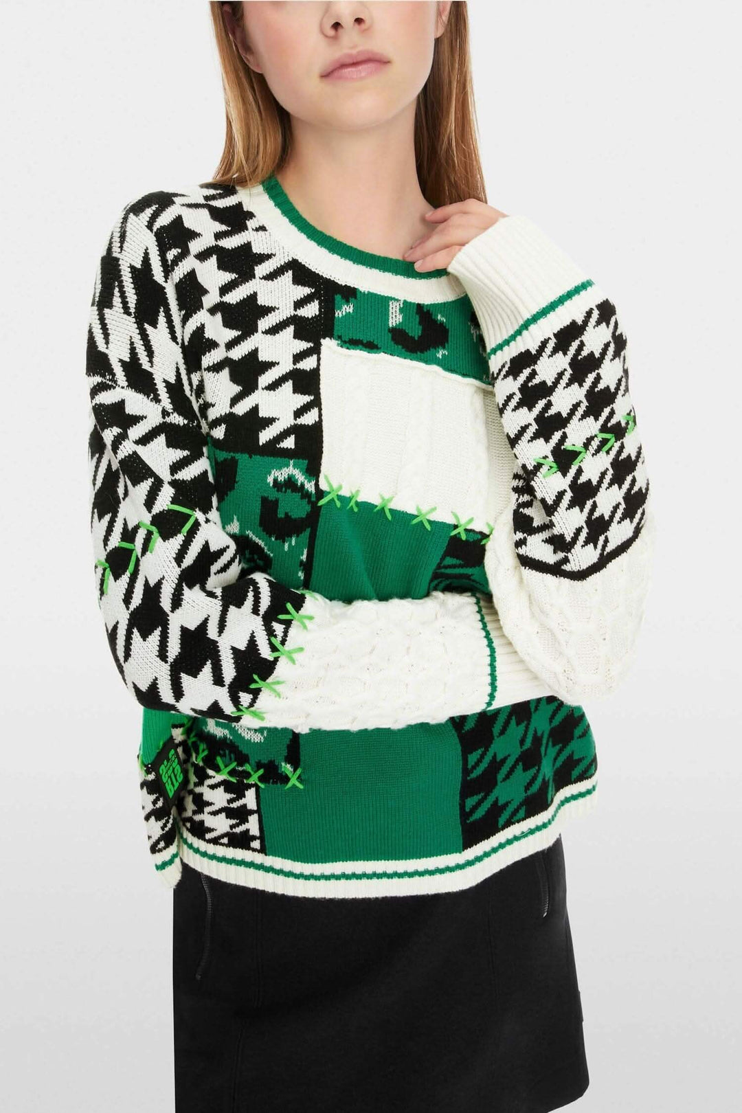 Pull en maille à motifs mélangés avec design patchwork en vert, noir et blanc, col rond, silhouette oversize.