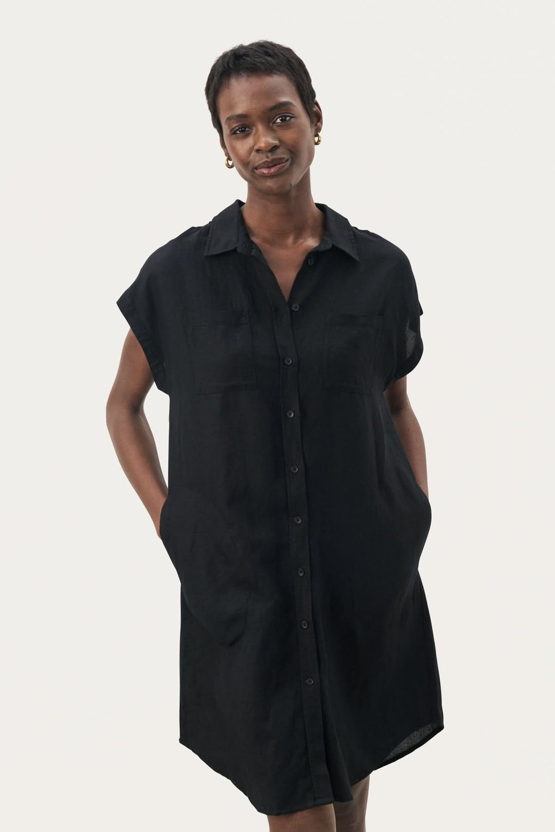 Robe Ellena noire pour femme, avec col chemise, manches courtes et poches, parfaite pour un look décontracté.