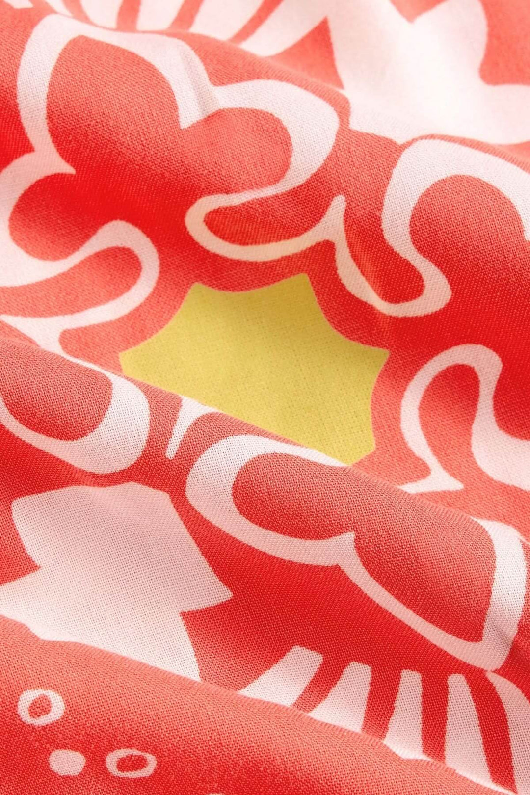 Imprimé floral audacieux en rouge et jaune sur tissu doux et fluide, parfait pour une robe estivale.