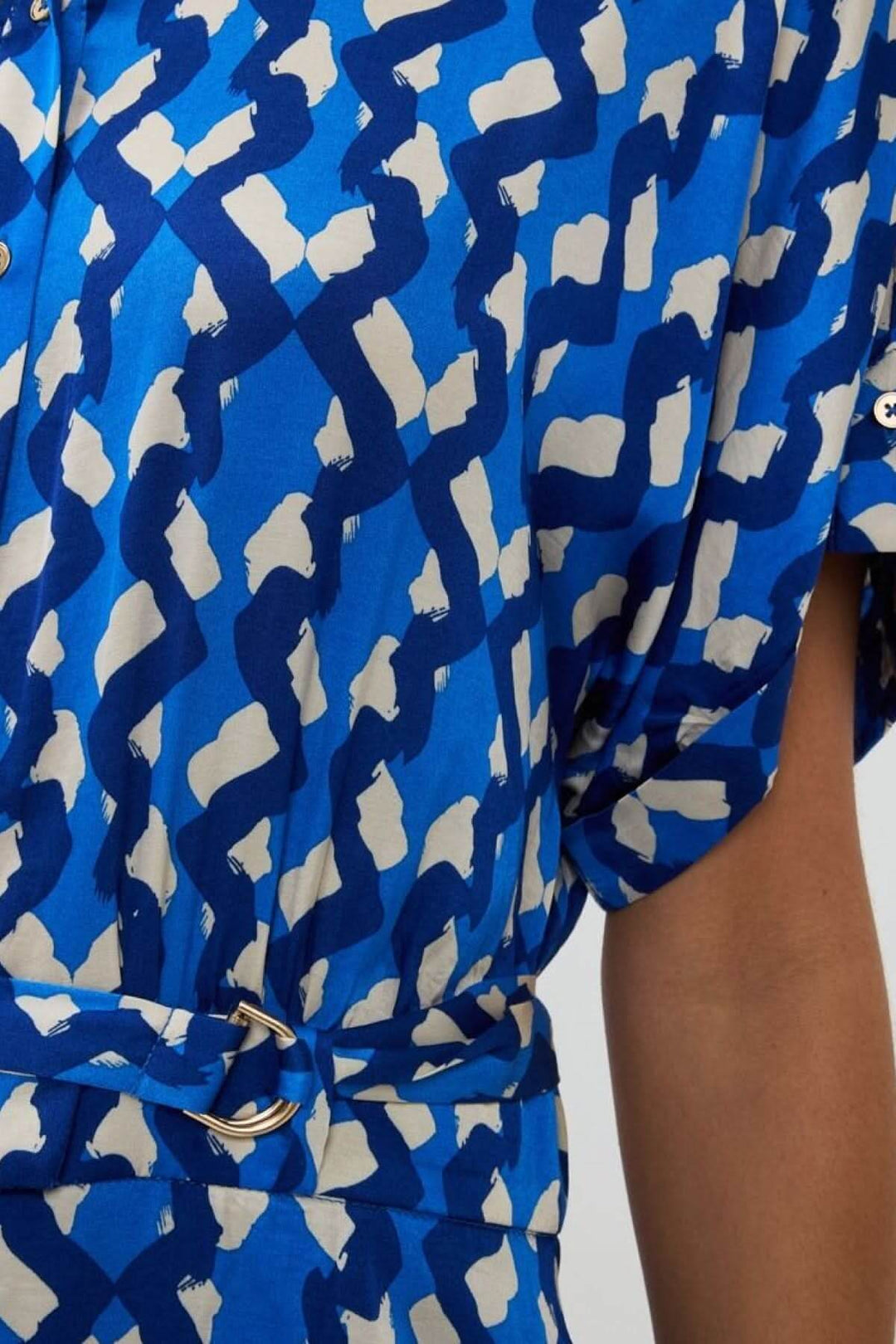 Détail d'une robe-chemise Utopia à imprimé abstrait avec ceinture, en tissu satiné bleu.