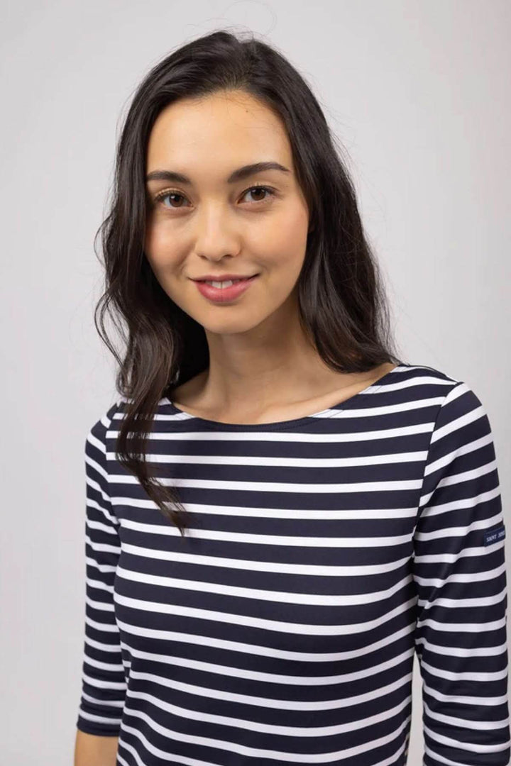 Femme souriante portant une robe marinière rayée, manches 3/4 et col rond, style féminin et moderne.