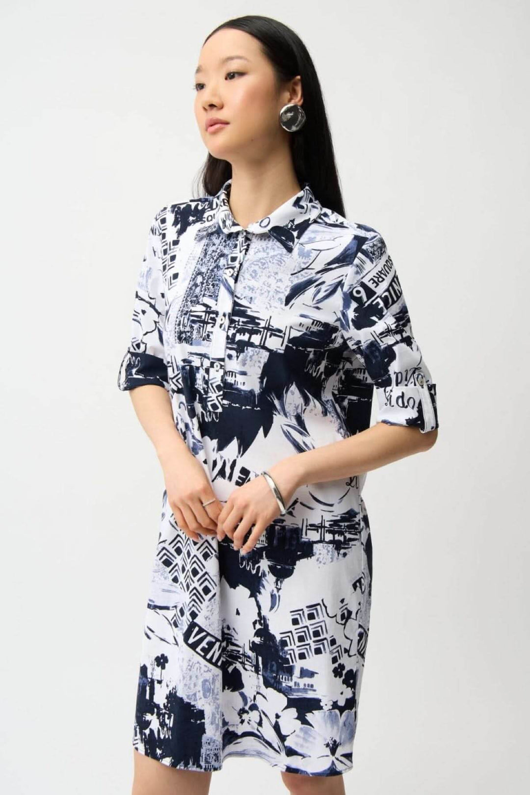 Robe chemise imprimée avec imprimé graphique urbain, col chemise, patte de boutonnage, coupe droite et fluide, portée par un mannequin.