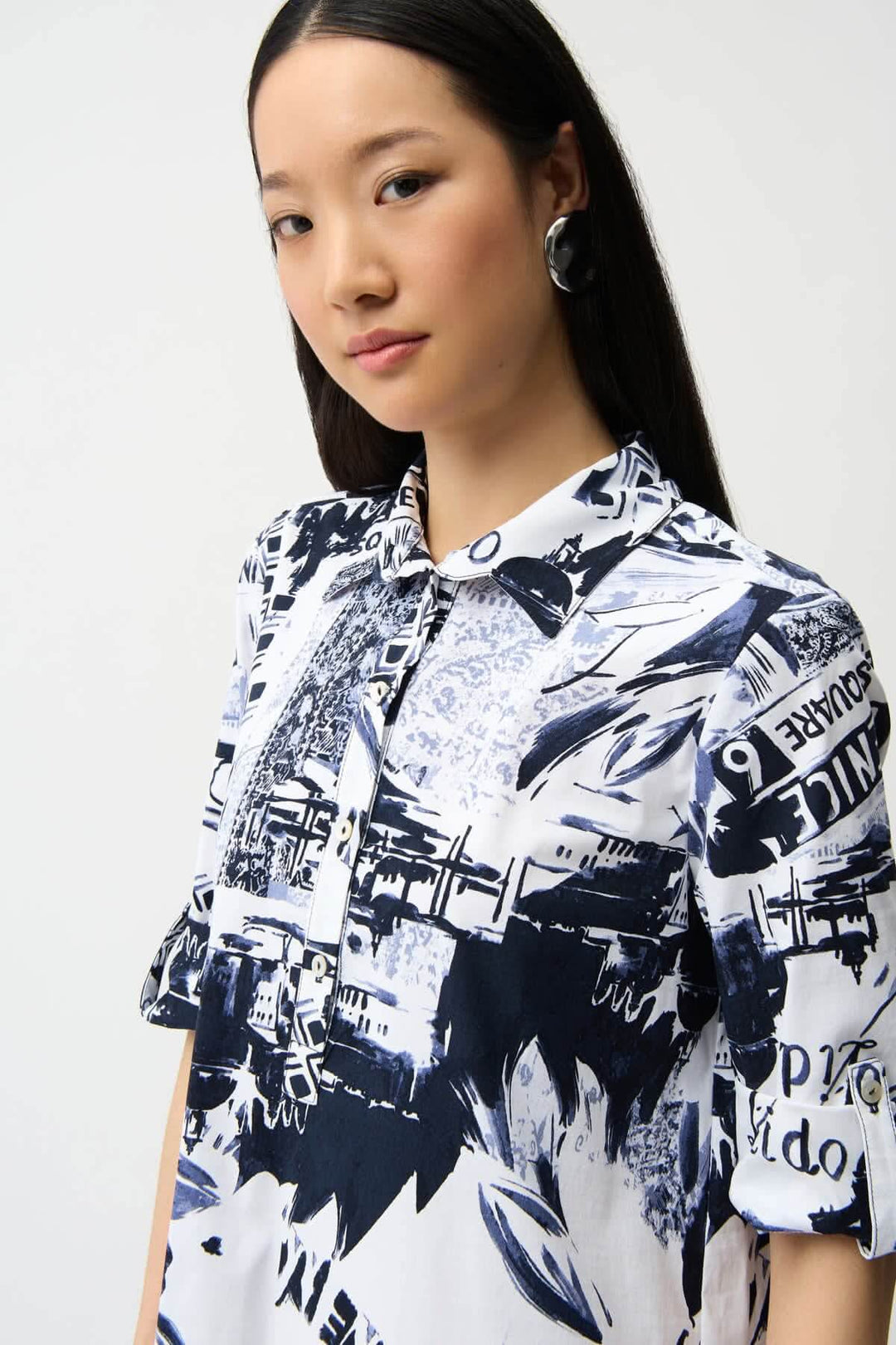 Femme portant une robe chemise imprimée avec un design graphique urbain et col structuré.