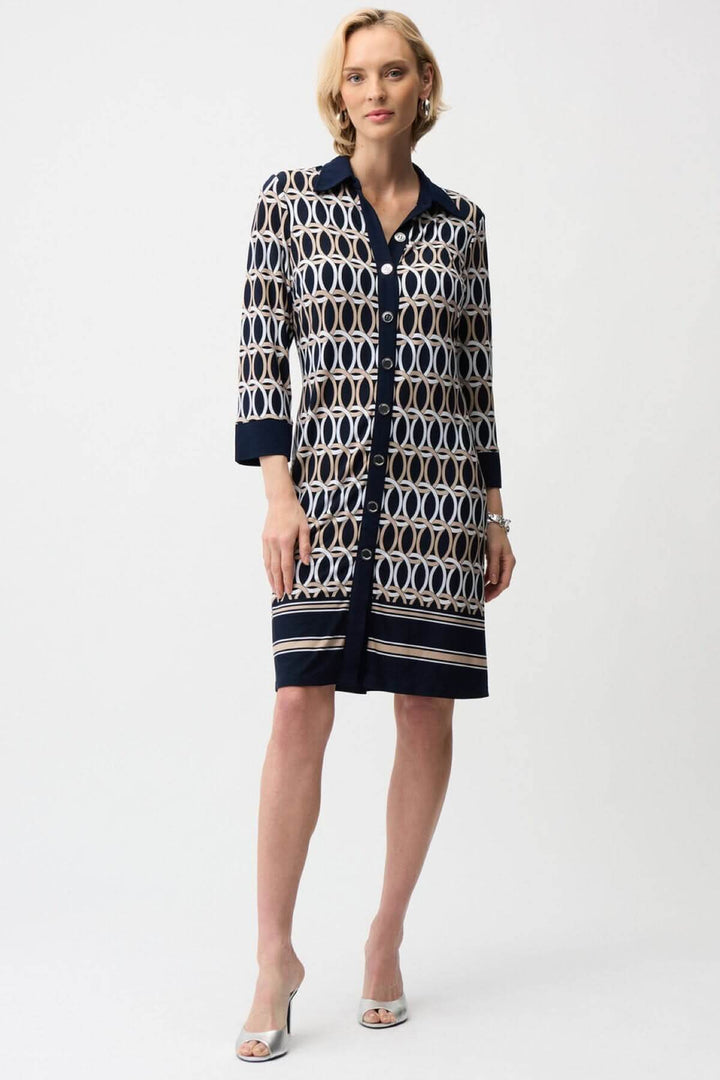 Femme portant une robe chemisier imprimée graphique avec motifs géométriques et fermeture boutonnée, élégante et polyvalente pour toutes occasions.