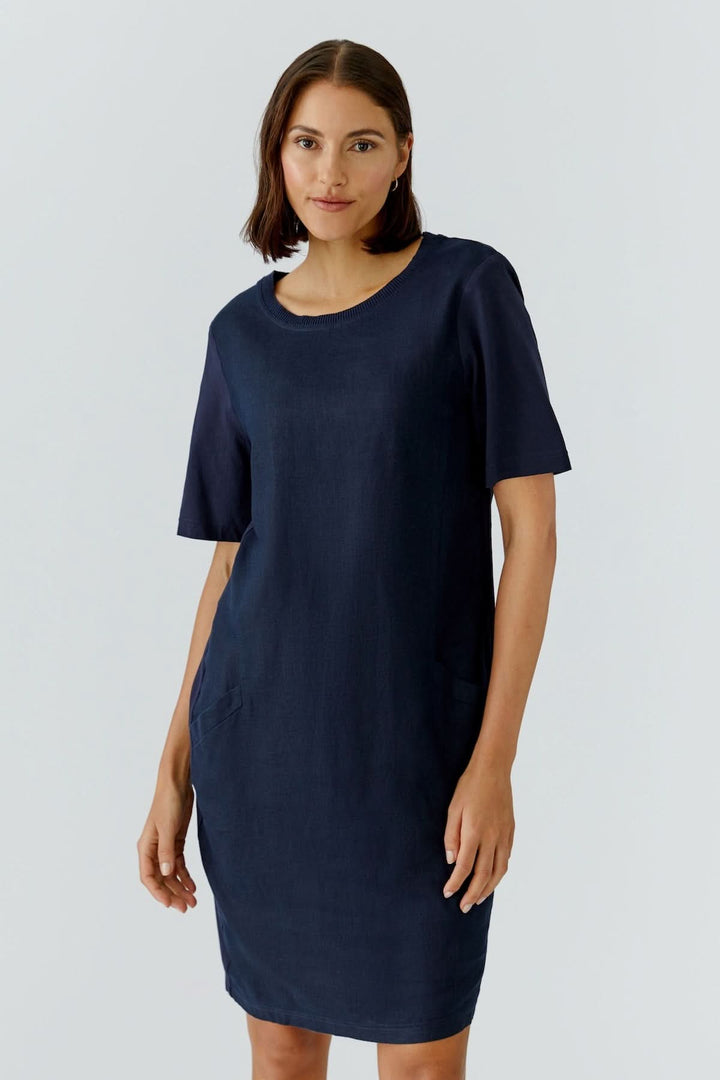 Femme portant une robe droite minimaliste manches courtes bleue, encolure ronde, style épuré