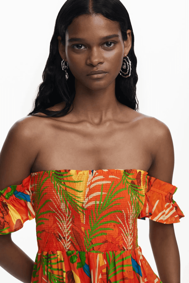 Robe d'été colorée avec imprimé tropical, bustier smocké et manches volantées, idéale pour les journées ensoleillées.
