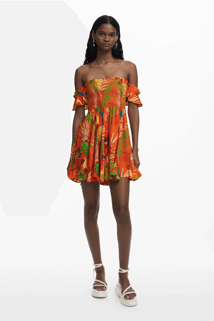 Robe d'été à imprimé tropical lumineux et bustier smocké, parfaite pour les journées ensoleillées.