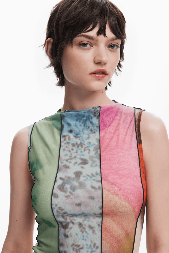 Robe à empiècements colorés avec motifs floraux, col rond et coupe ajustée, présentée par un modèle.