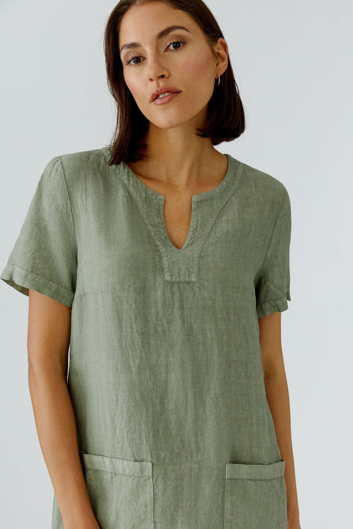 Robe en lin à manches courtes avec encolure ouverte et poches plaquées, idéale pour un look naturel et décontracté.