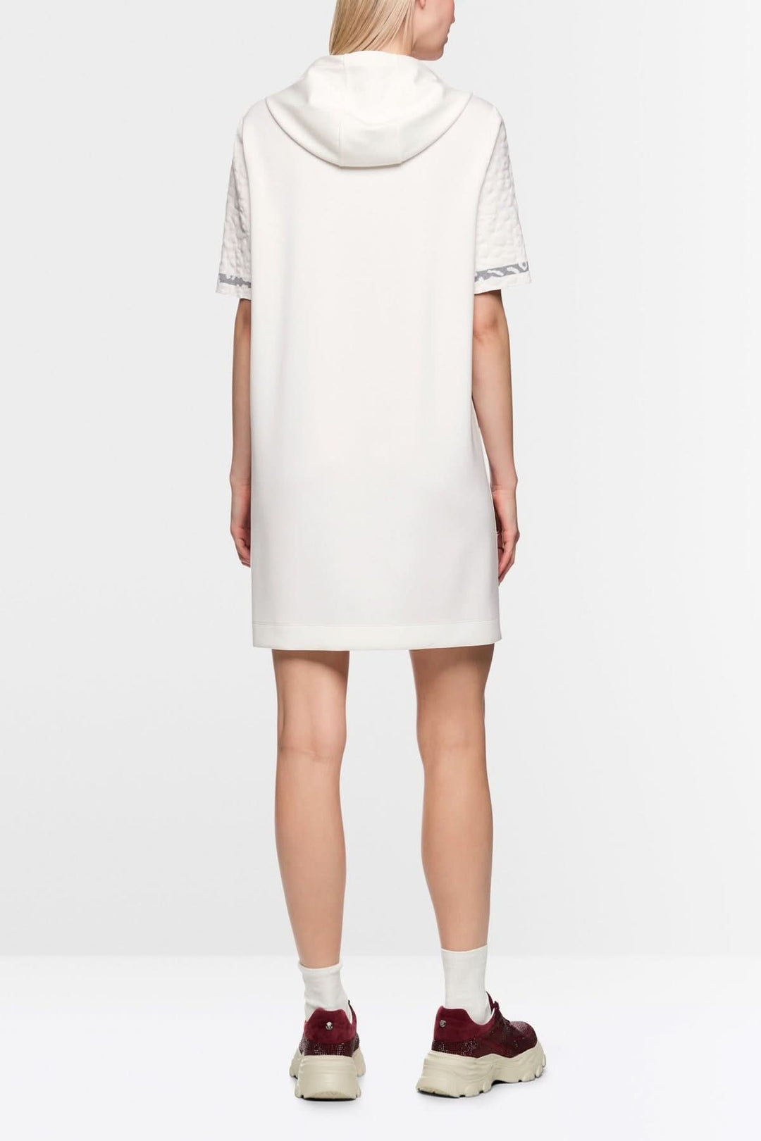 Vue arrière d'une robe en maille léopard à capuche blanc avec manche tricotée, portée par un modèle de dos. Savoir-faire Knitted in Germany.