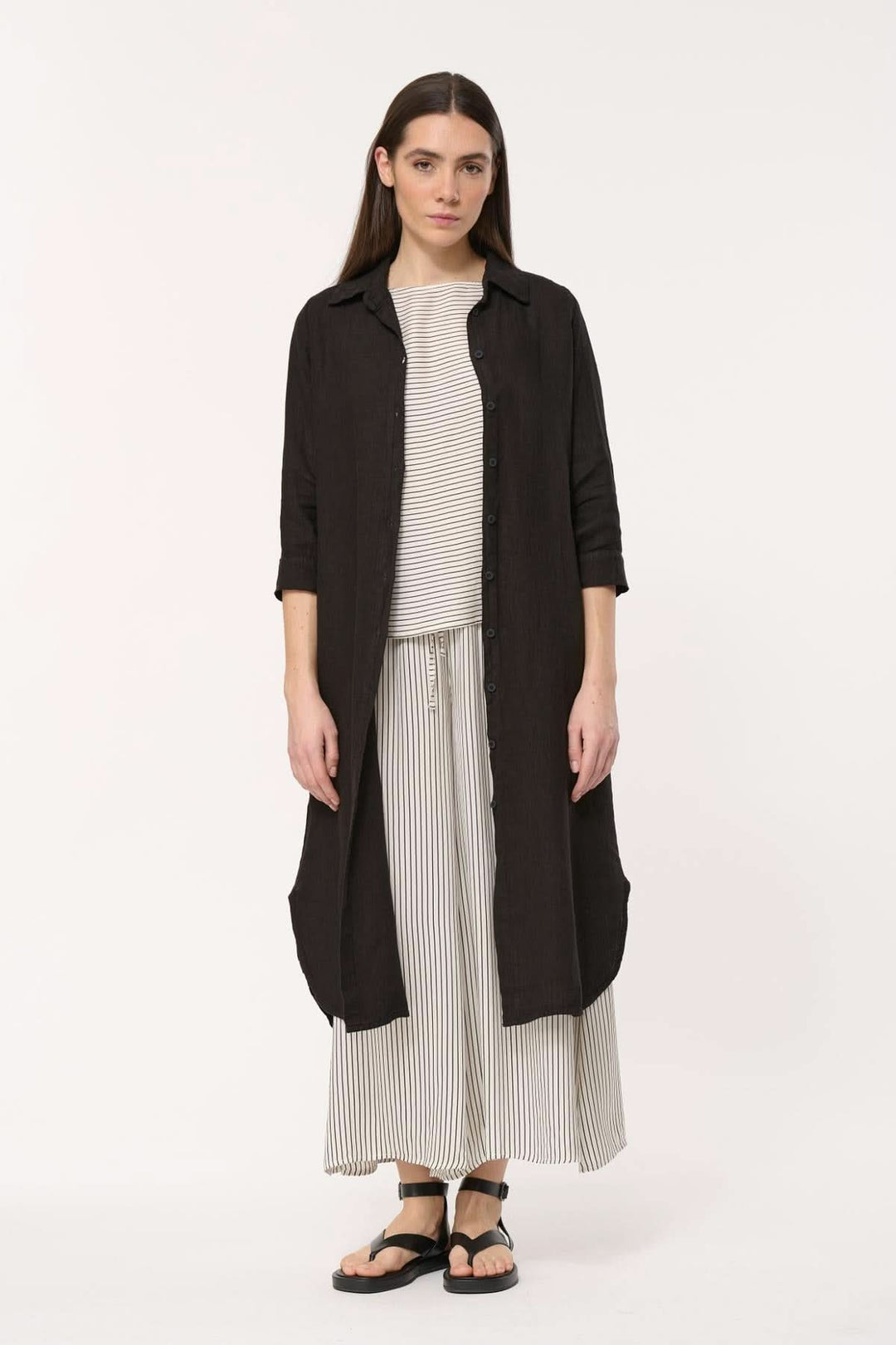 Robe longue Talicia en lin avec col chemise, manches longues et coupe fluide, portée avec un top rayé.