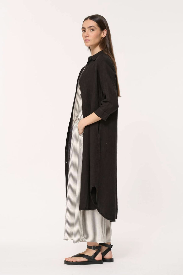 Robe longue Talicia en lin, coupe fluide et col chemise, portée avec simplicité et élégance.